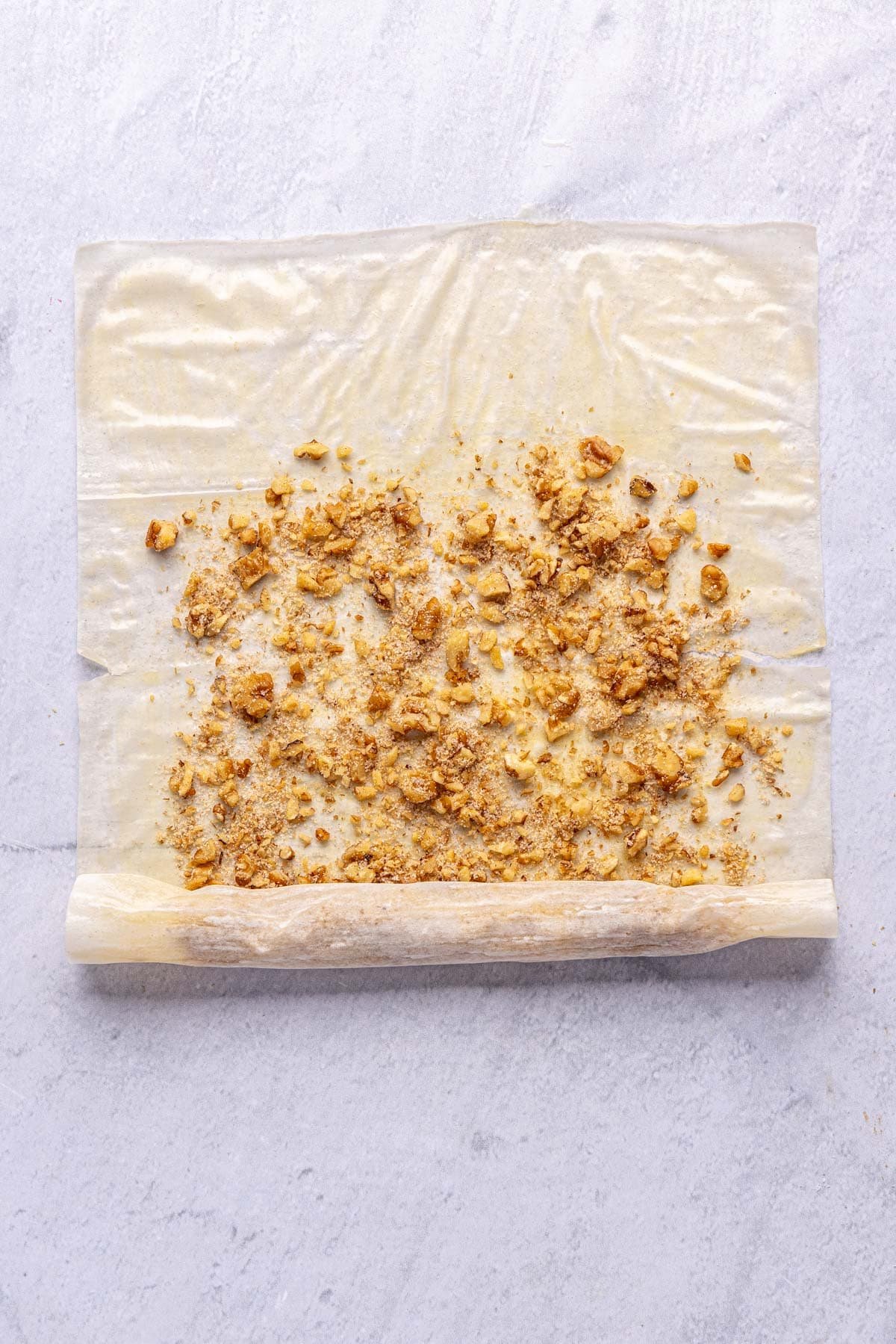 After rolling ghee coated phyllo sheet about half way up.