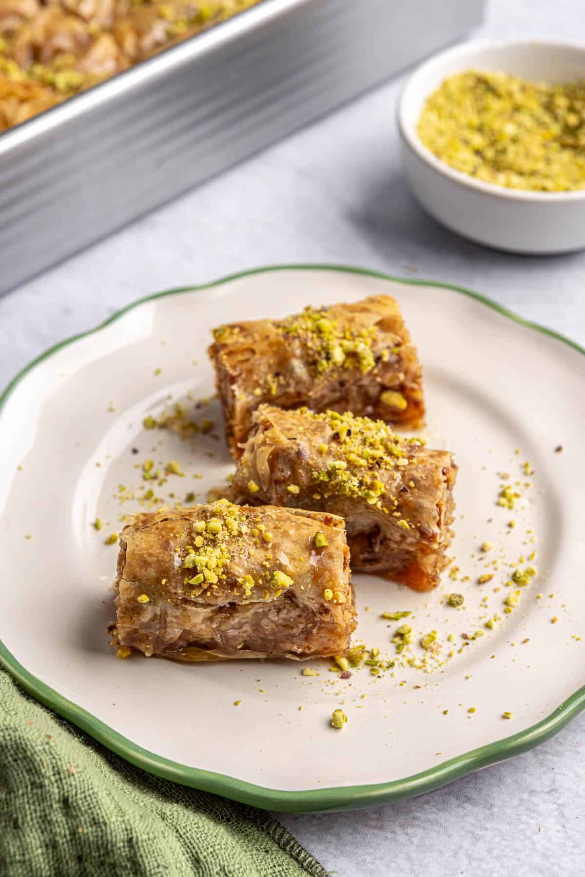 Three Burma Baklava rolls on a small plate.