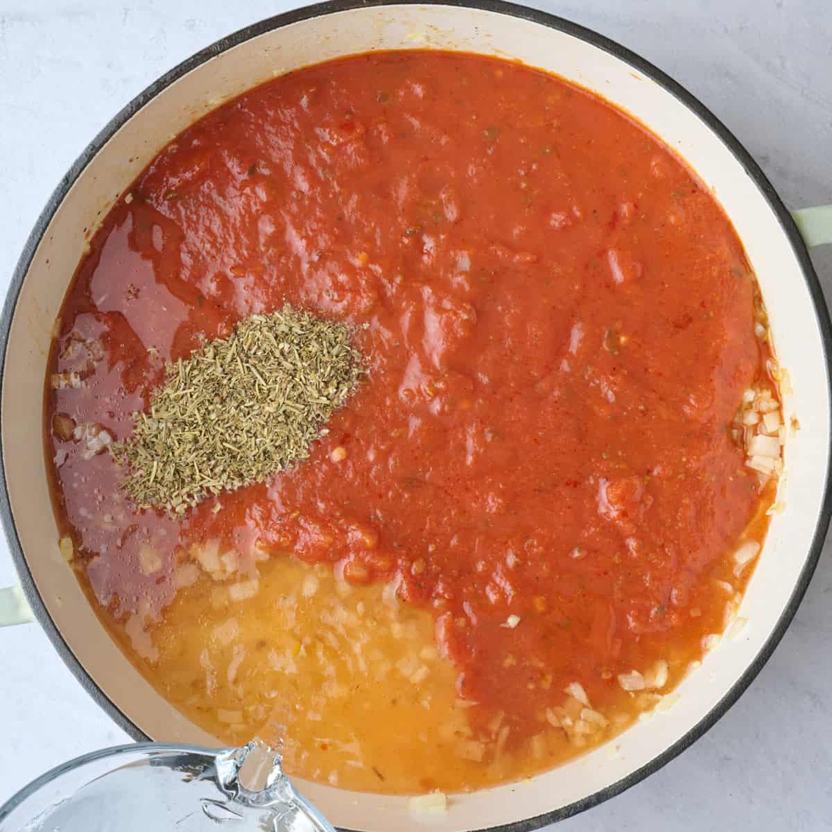 Marinara, water and seasonings added to the onions and garlic, before mixing.