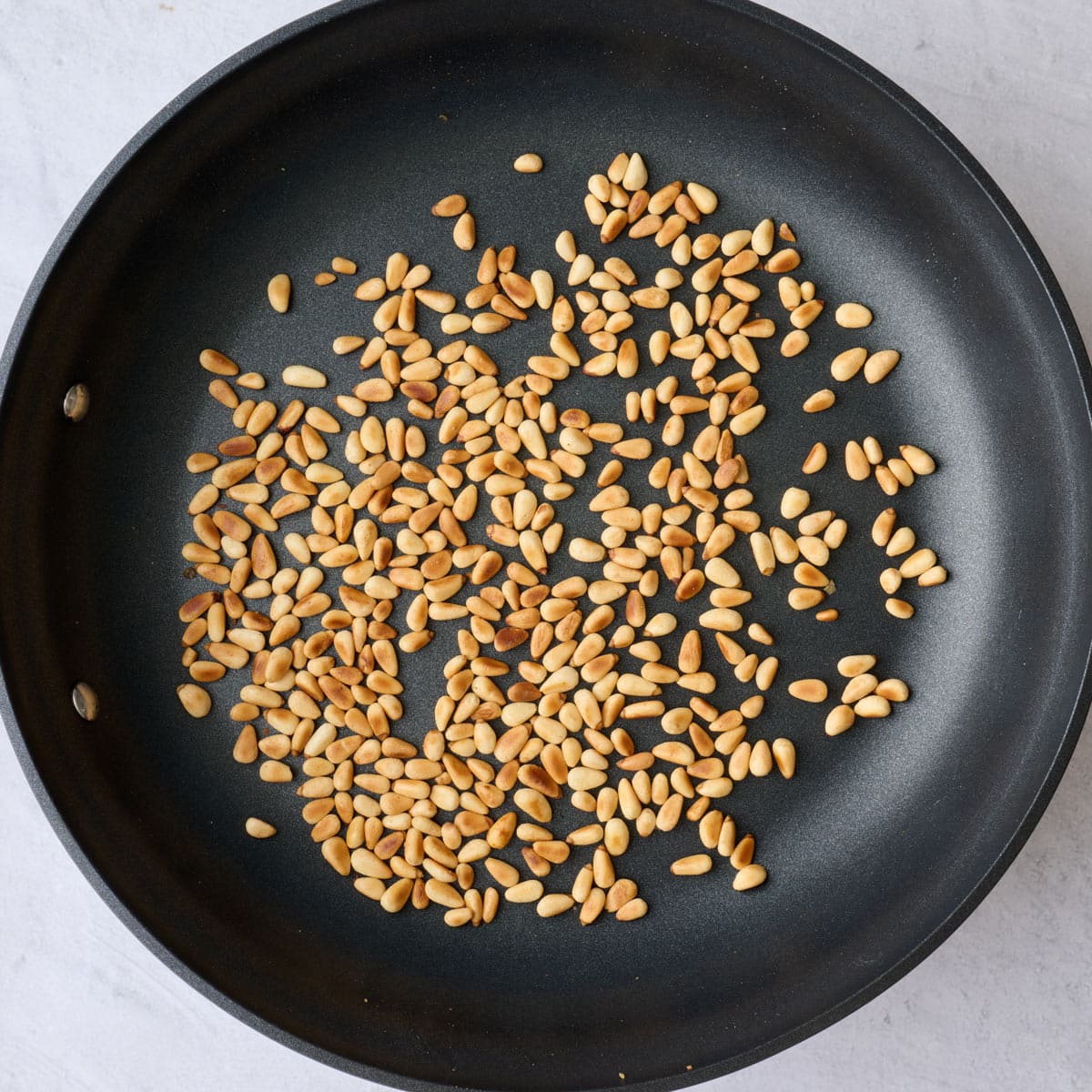 Pine nut in a large non stick skillet after toasting.