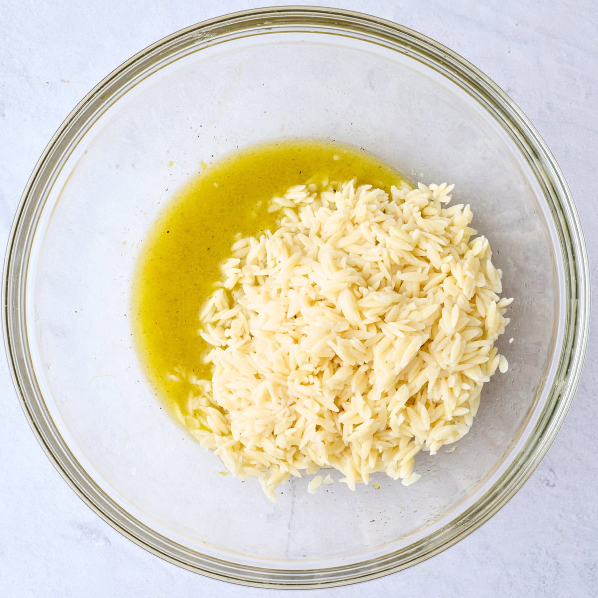 Cooked orzo on top of dressing before tossing together.