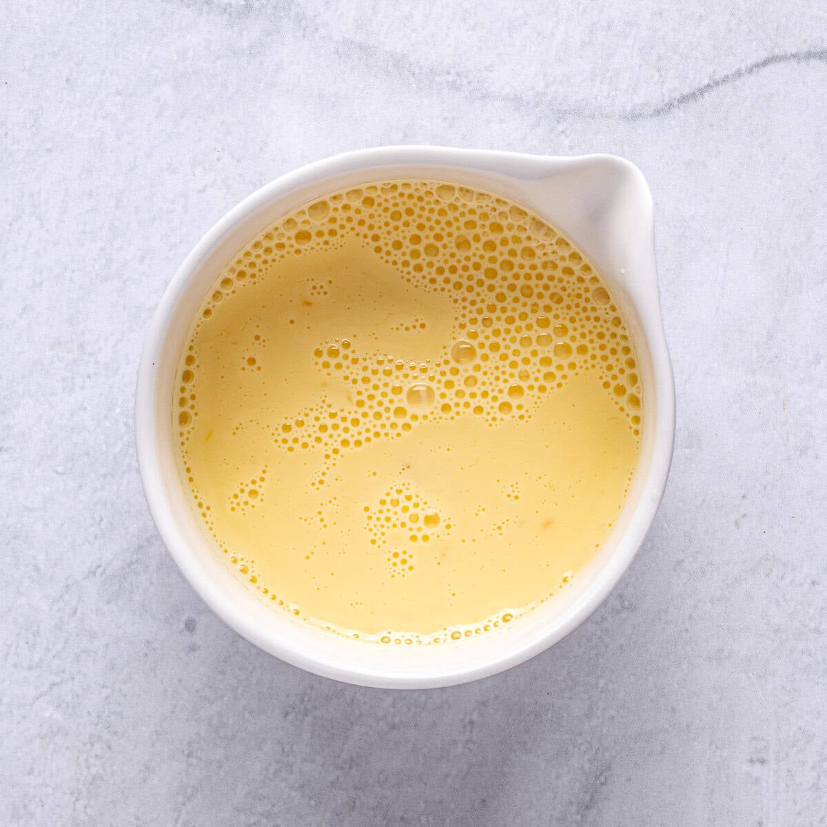 A bowl of whisked egg and milk.