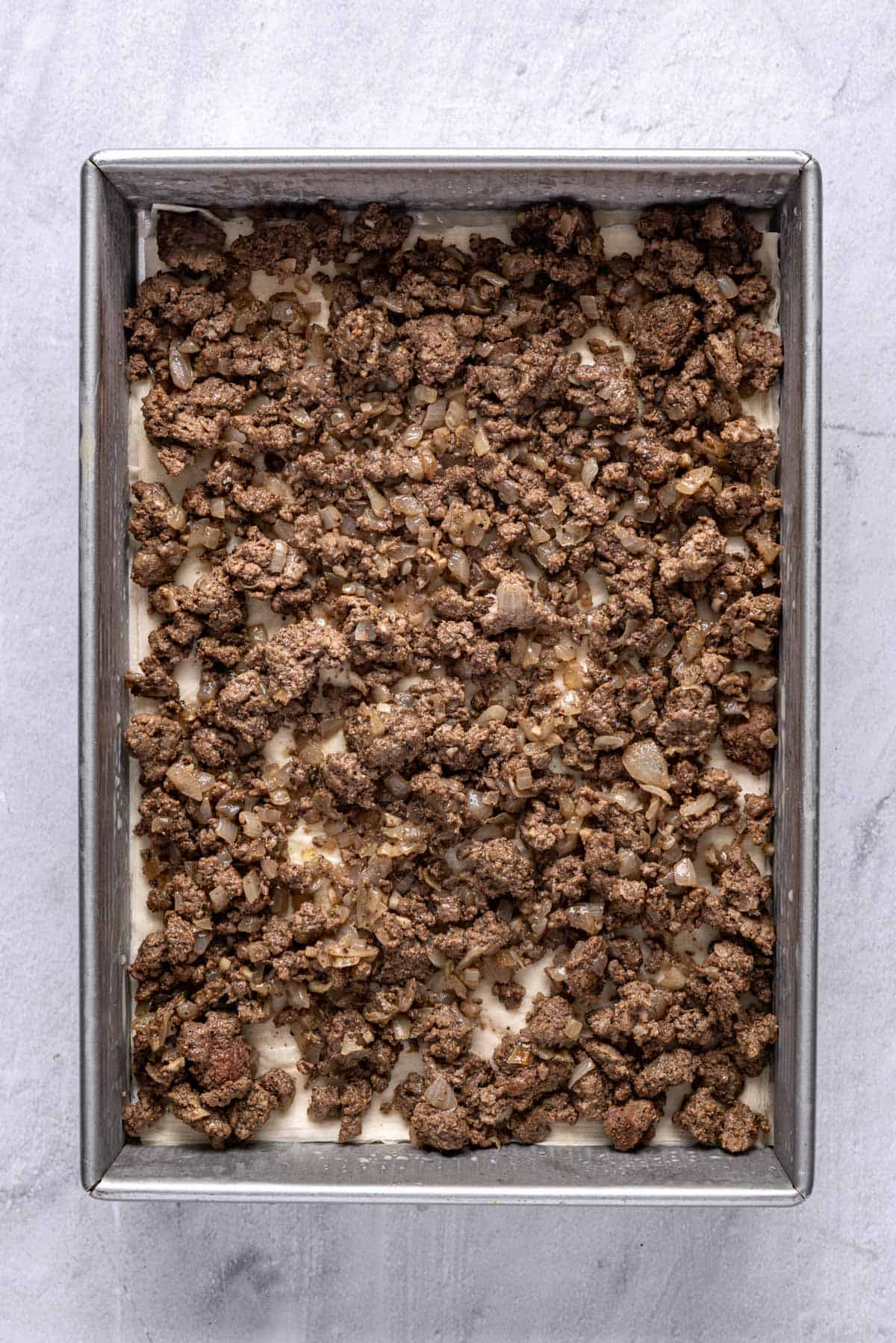 Ground beef mixture spread evenly on top of the phyllo.