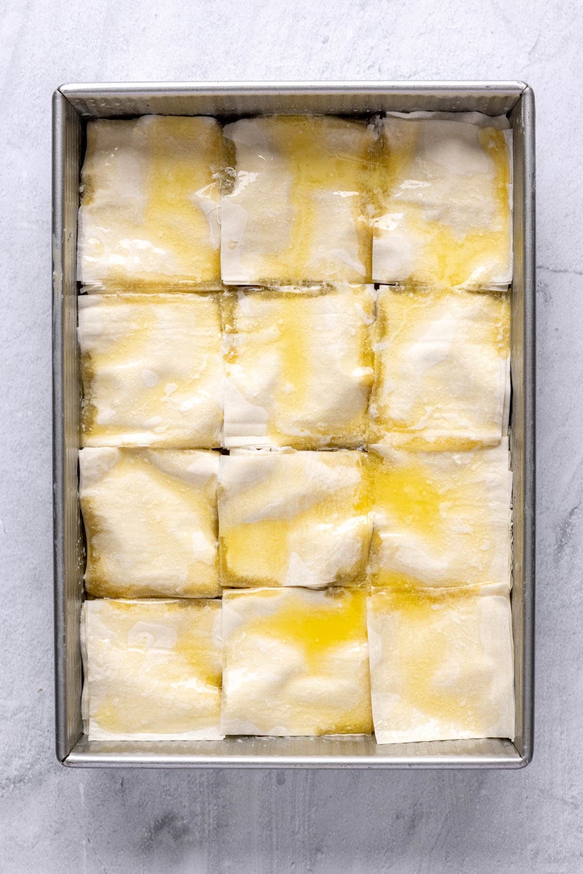 Melted butter poured over the phyllo squares.