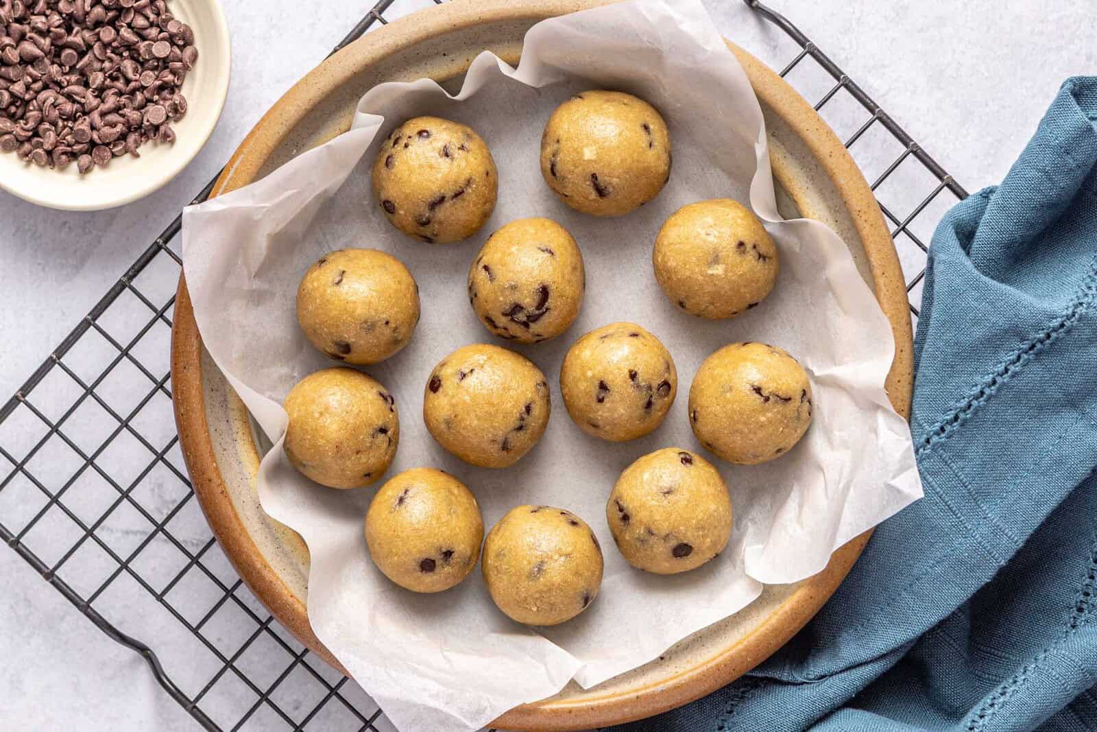 Easy protein balls recipe on a dish with chocolate chips nearby.