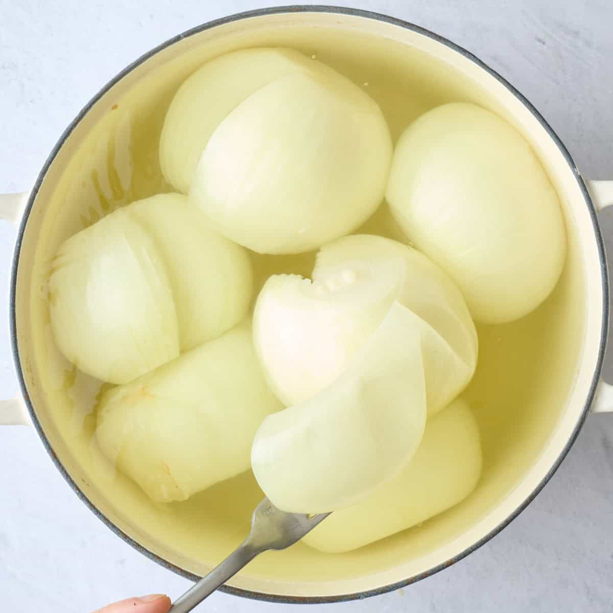 Whole onions after boiling showing the layers peeling off easily.