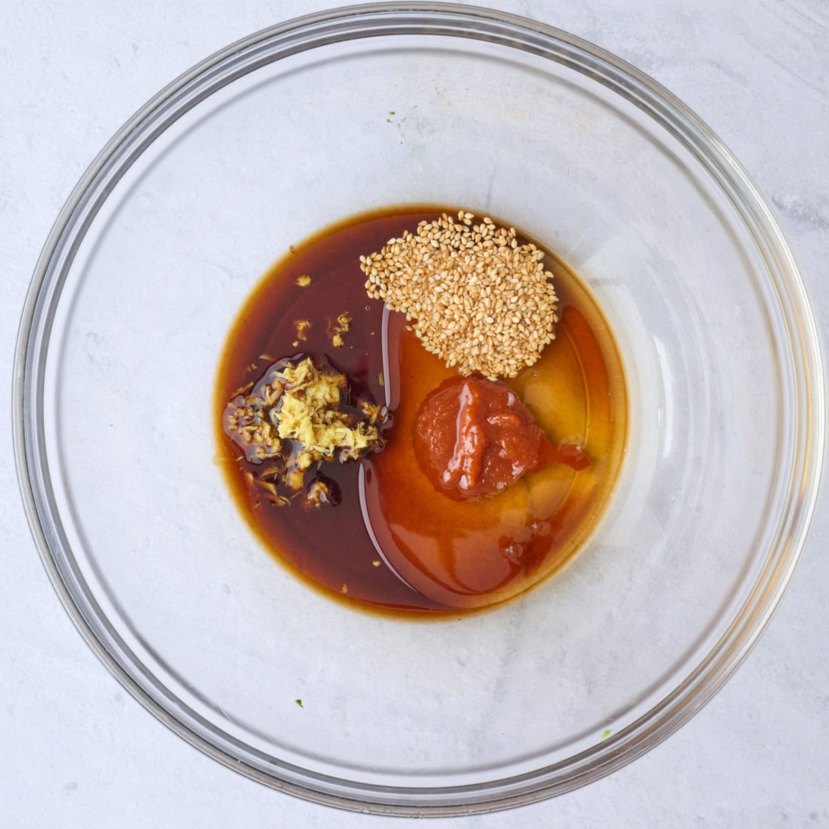 Recette de salade de concombre à l'asiatique 8 Mélanger la sauce soja, le vinaigre, l'huile, la Sriracha, le gingembre et les graines de sésame dans un petit bol avant de mélanger.