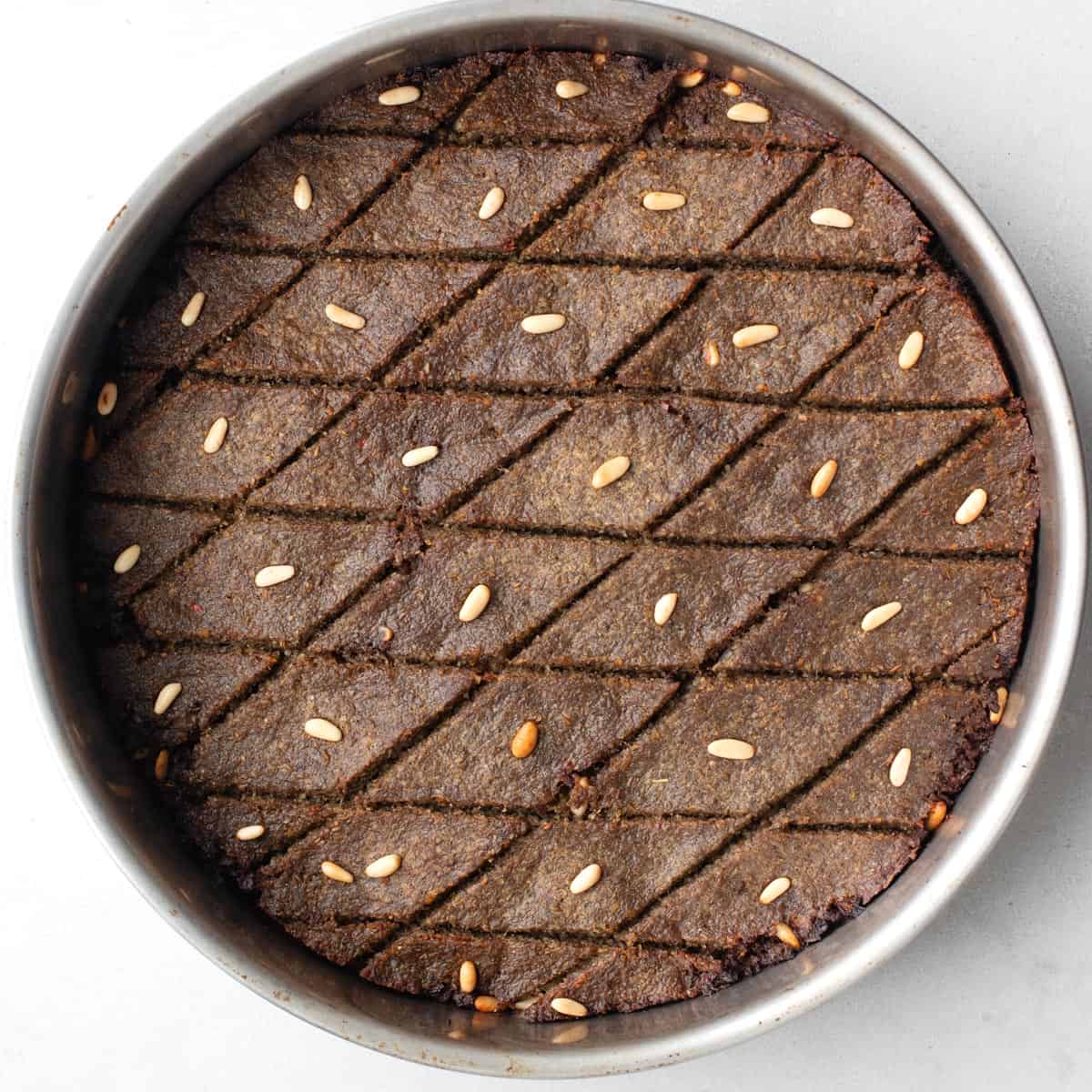 Kibbeh after baking and well browned with toasted pine nuts.