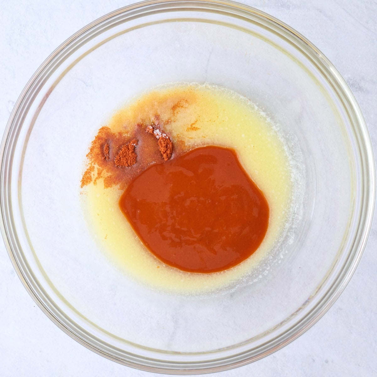 Melted butter, hot sauce, paprika, garlic powder and salt in a large bowl before mixing.