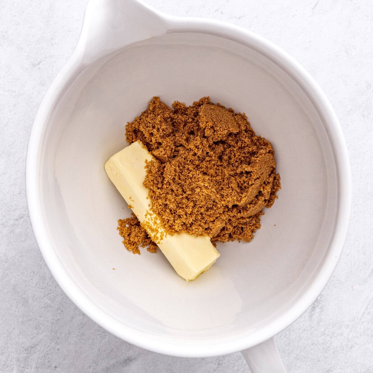 Butter and brown sugar in the bowl of a stand mixer before creaming together.