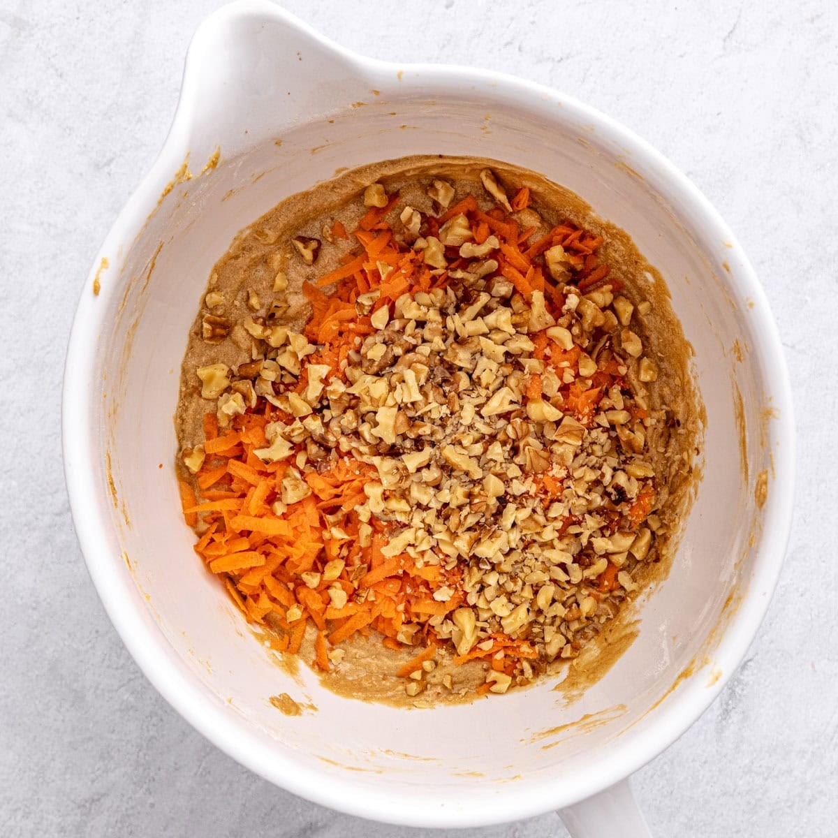 Shredded carrots and walnuts added on top of quick bread batter.