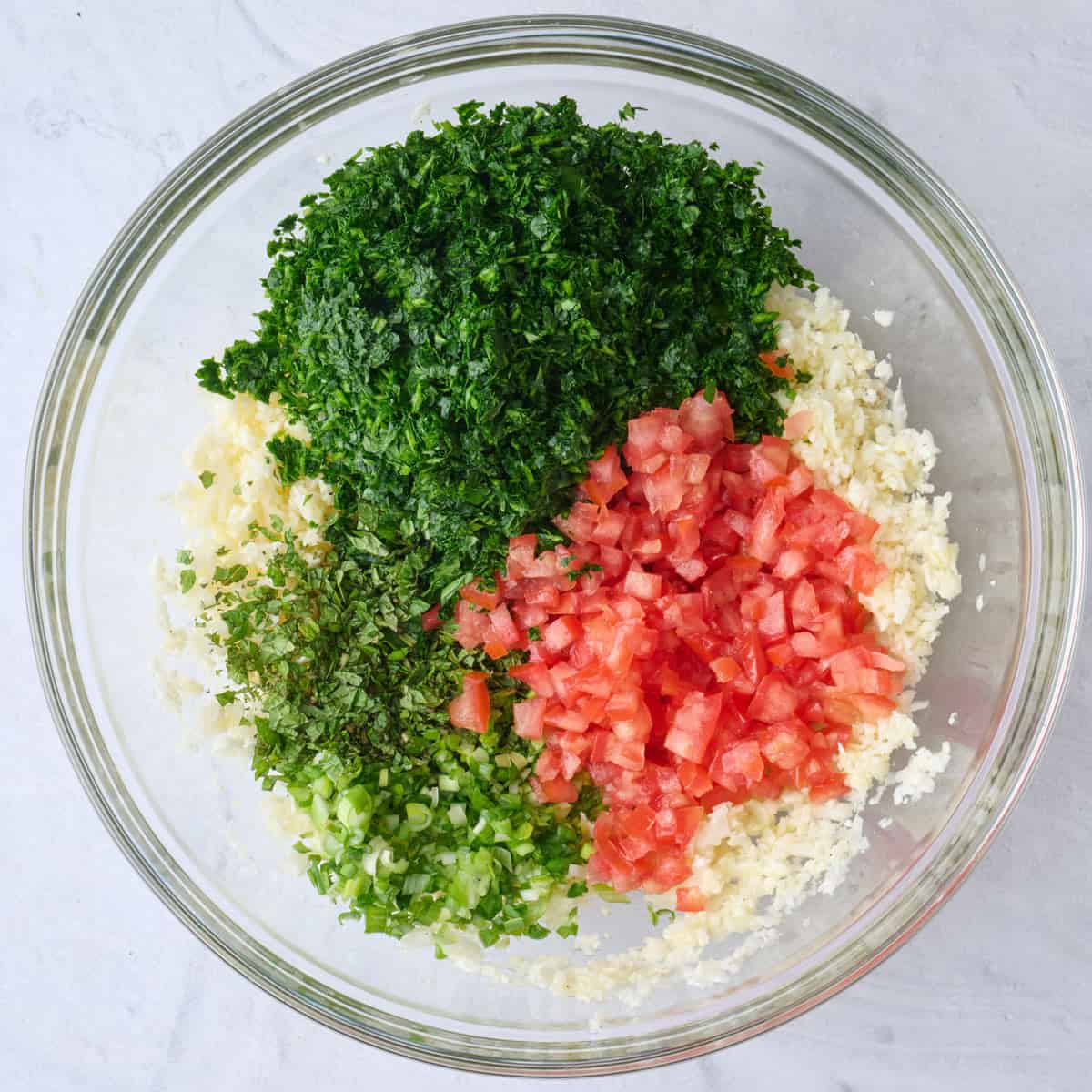 Chopped parsley, mint, green onions and tomatoes added on top of riced cauliflower.