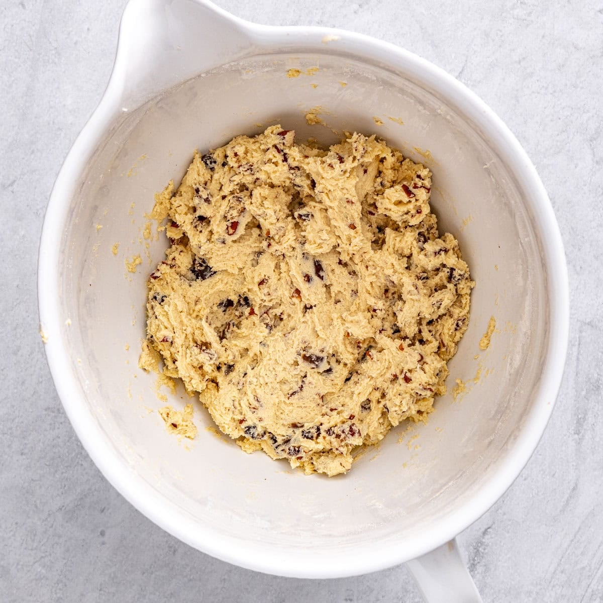 Cookies dough in a mixer bowl after folding in chopped dates and pecans.