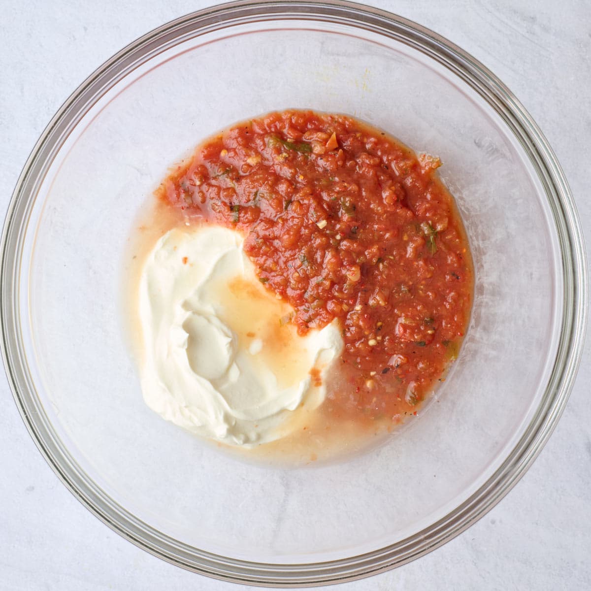 Sour cream, salsa and lime juice in a bowl before mixing.