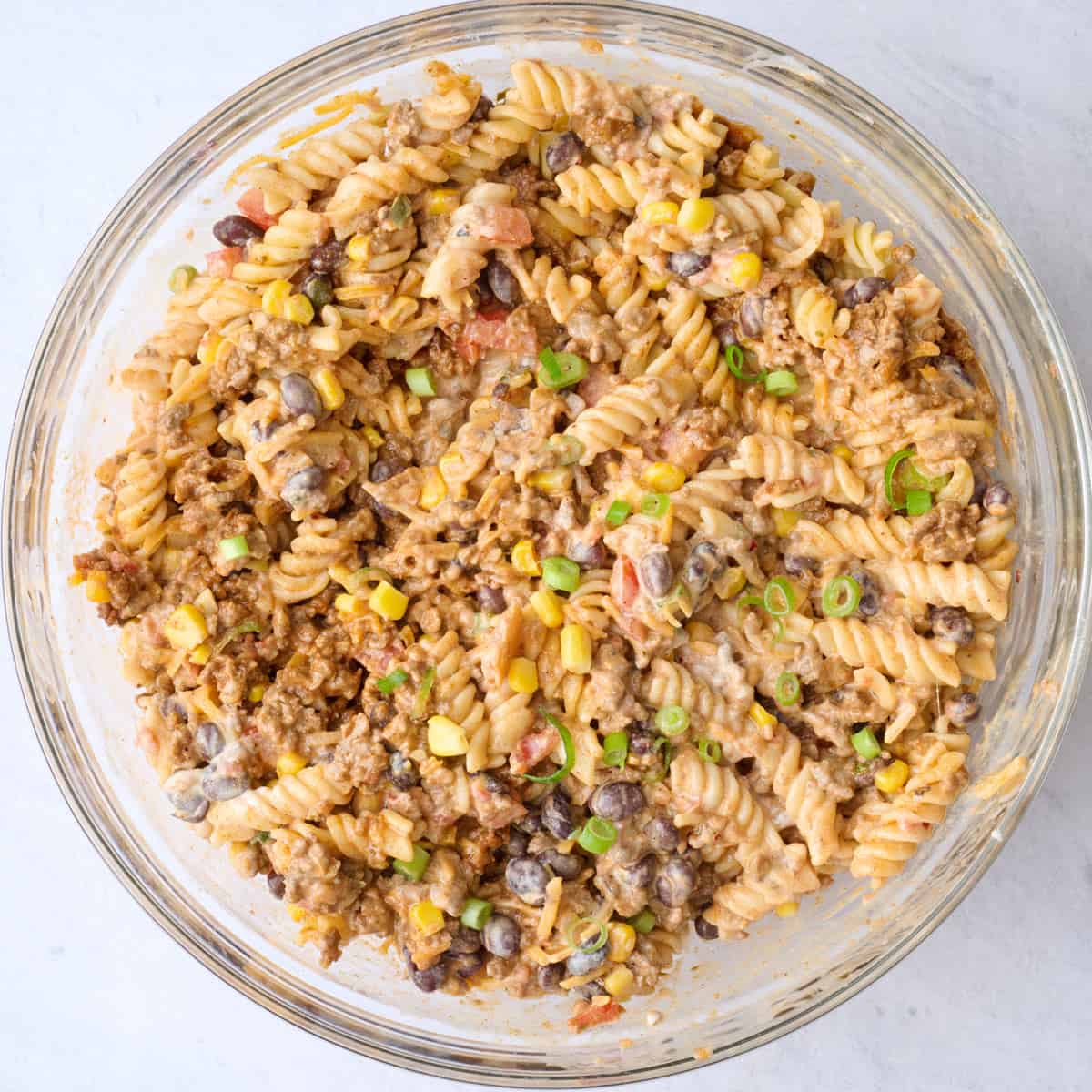 Pasta and taco ingredients after tossing together in the taco pasta salad dressing.