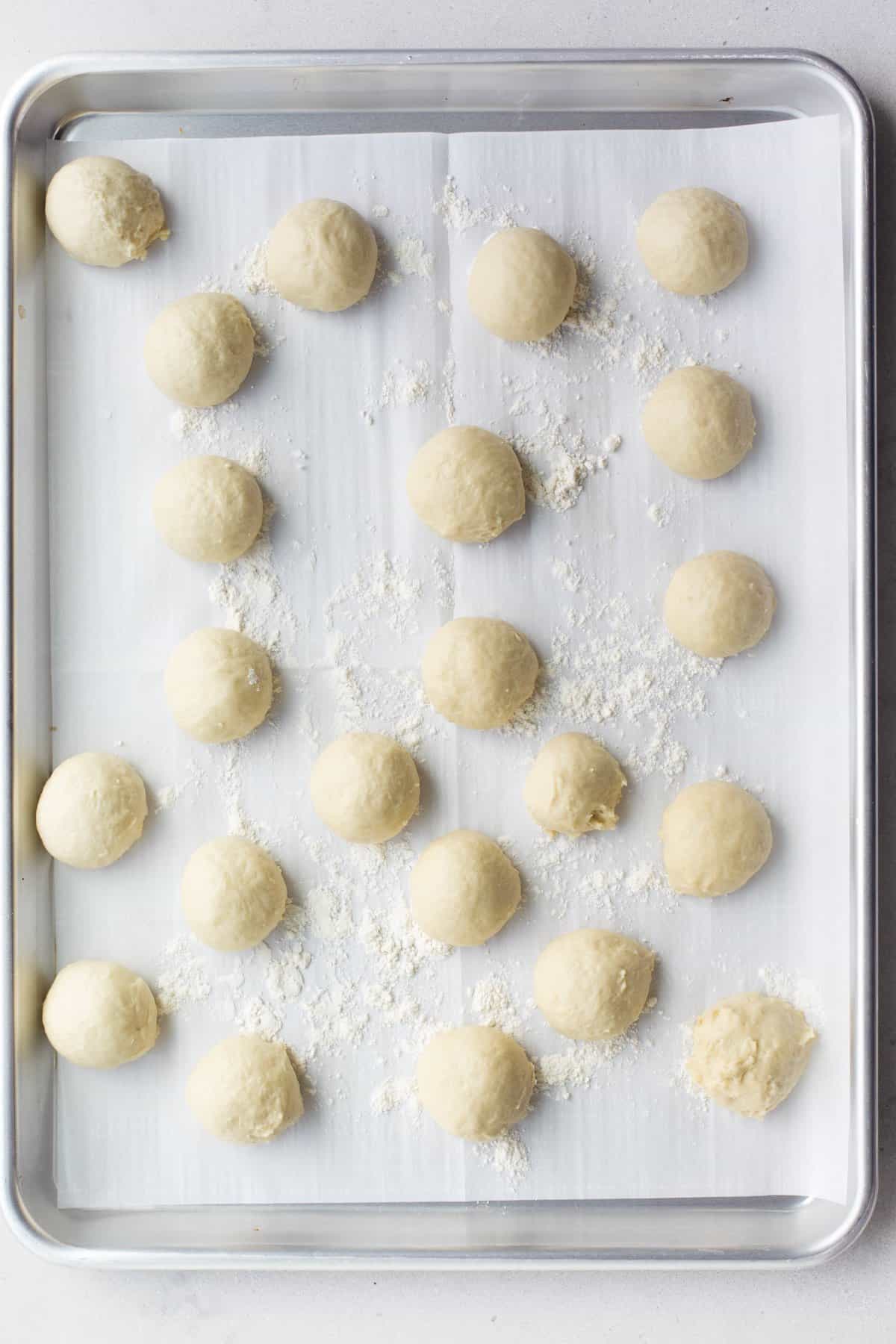 Dough balls on a parchment lined sheet pan.