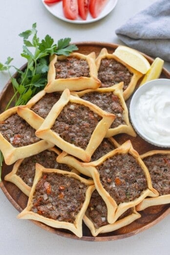 Easy Lebanese meat pie recipe served on a platter with a small dish of yogurt.