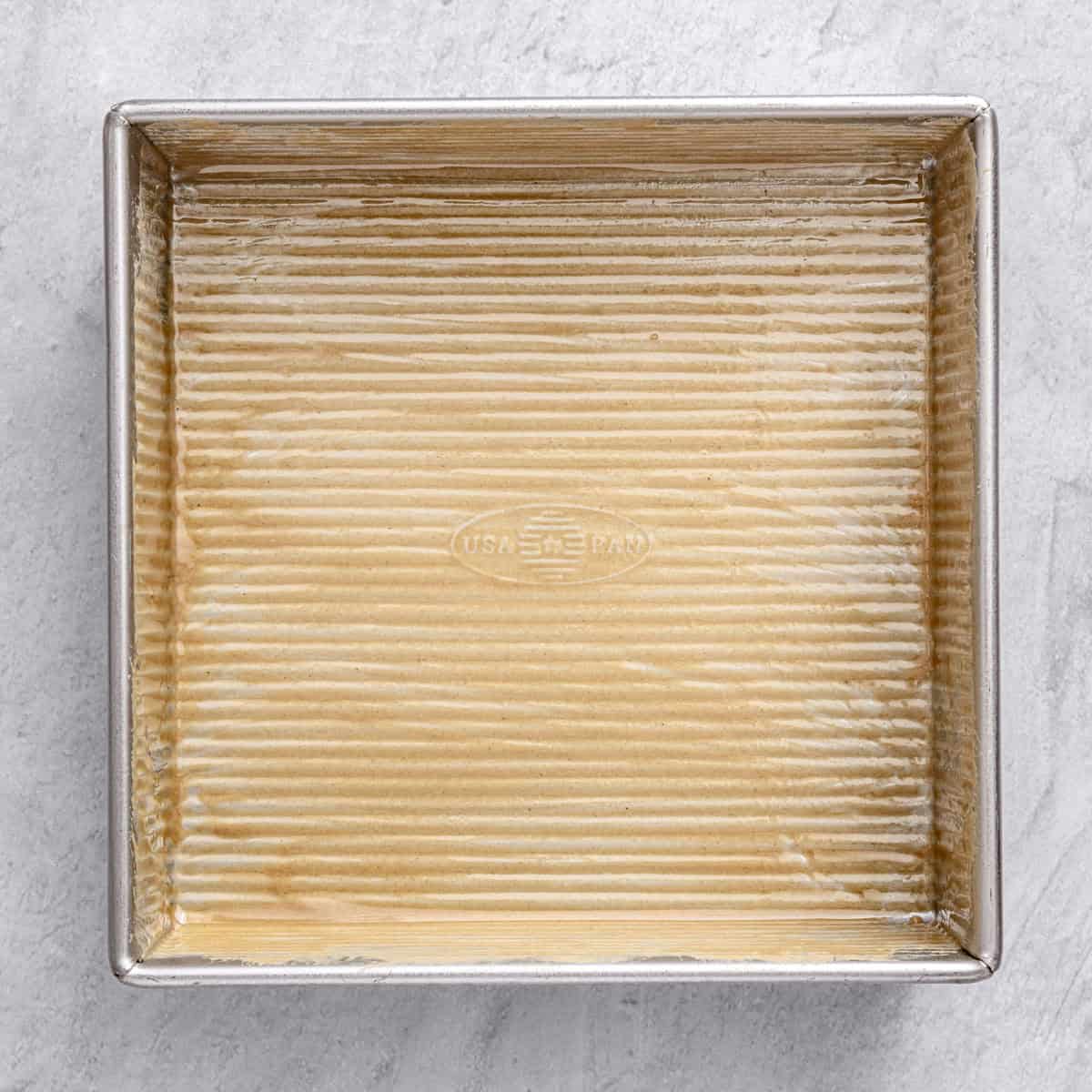 Tahini brushed into baking pan for Lebanese cake recipe.