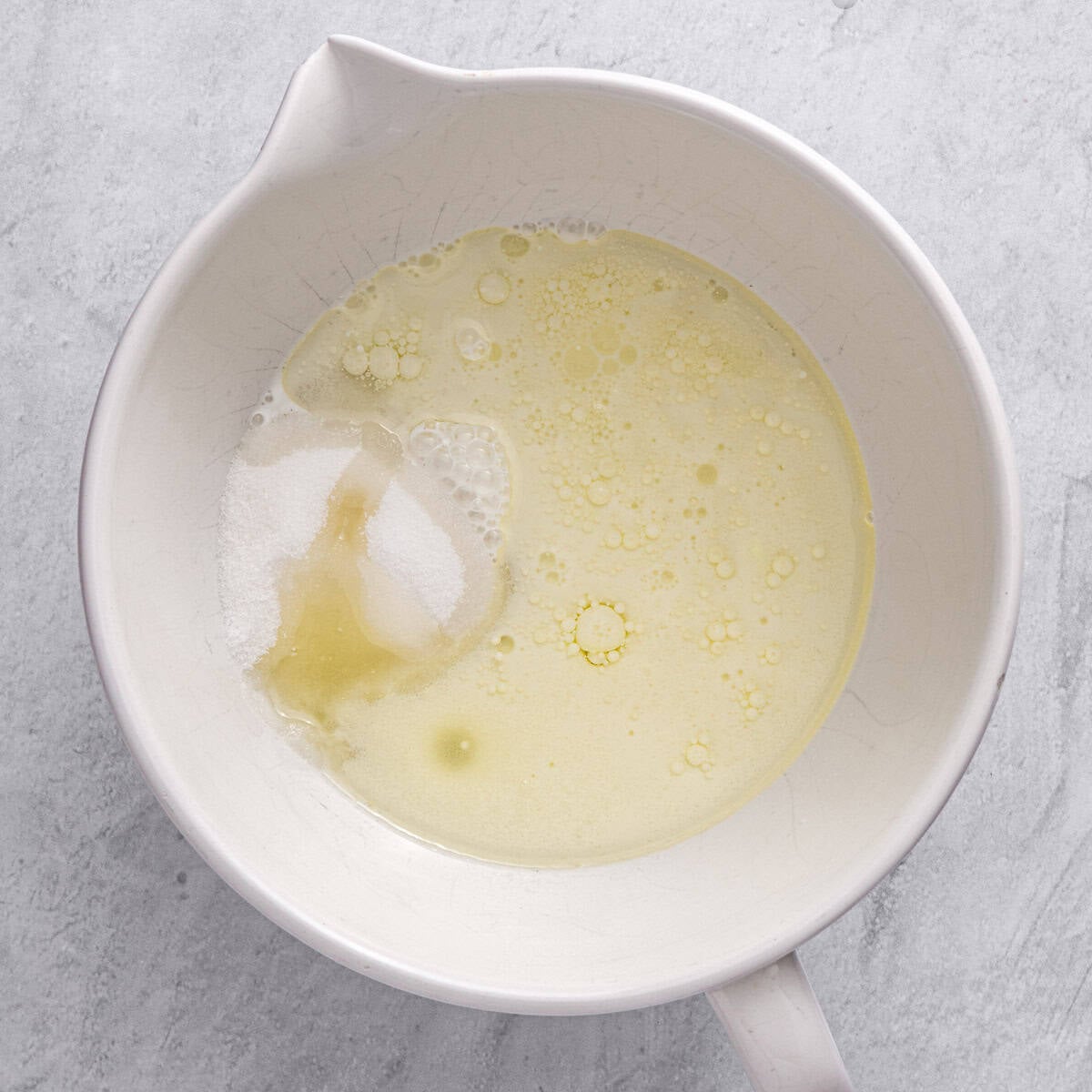 Oil, milk, and sugar in a bowl before combining.