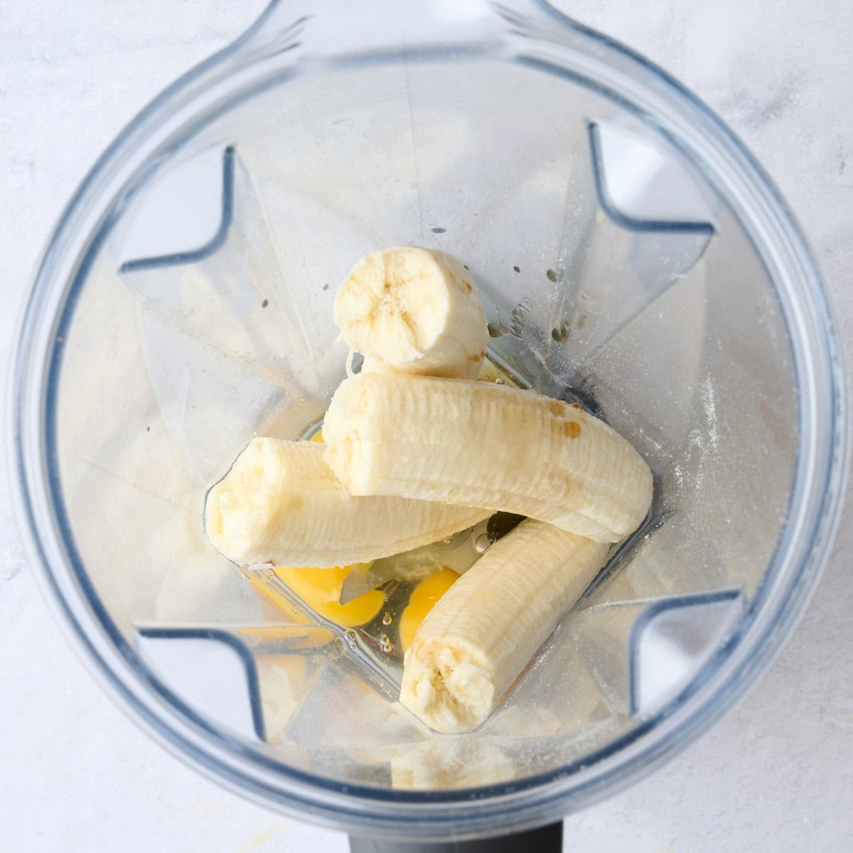 Bananas, eggs and vanilla in a blender before blending.