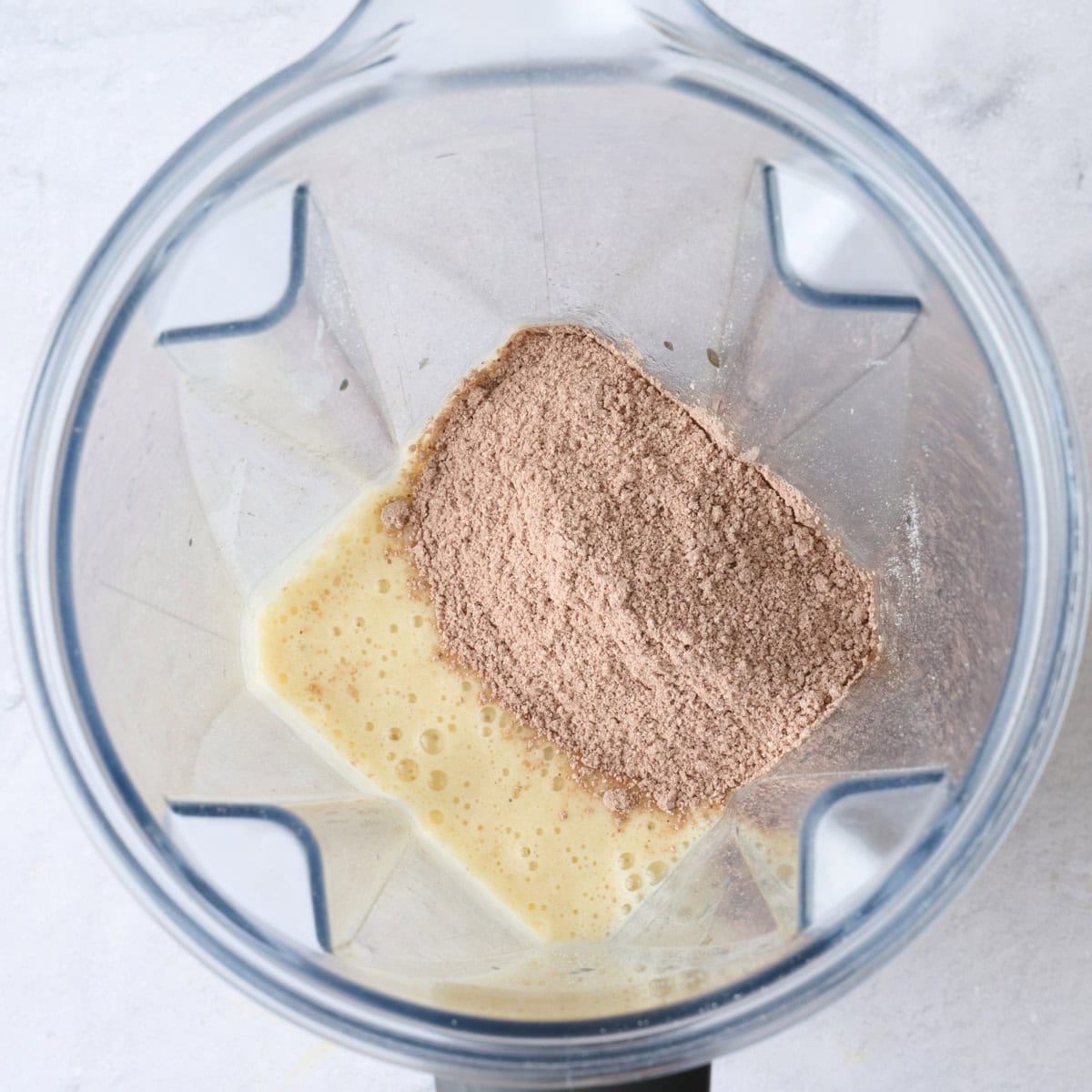 Eggs and bananas after blending smooth with dry ingredients added before mixing.