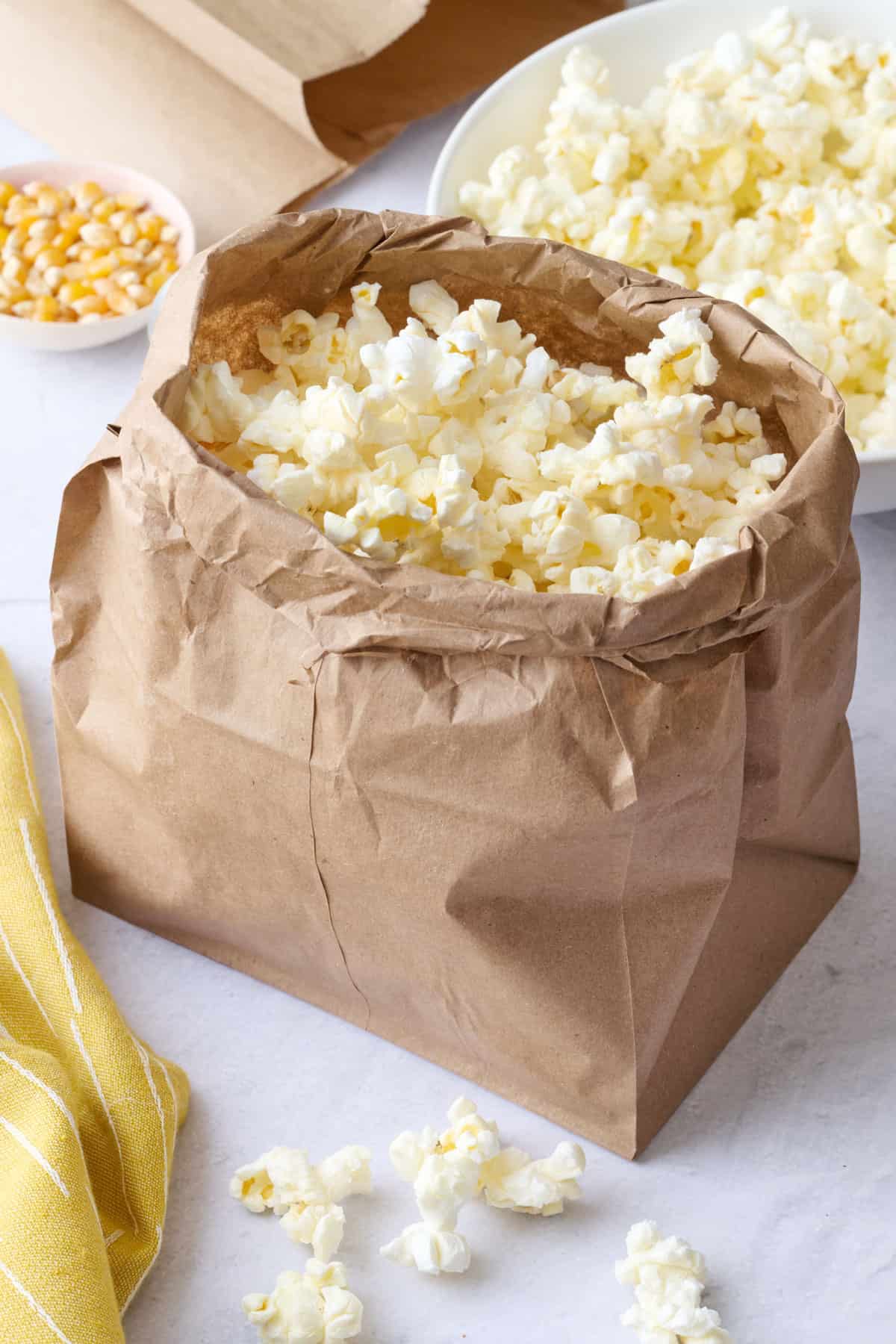 Popcorn in the brown paper bag with the sides rolled down so the popcorn is fluffed up taller than the sides.