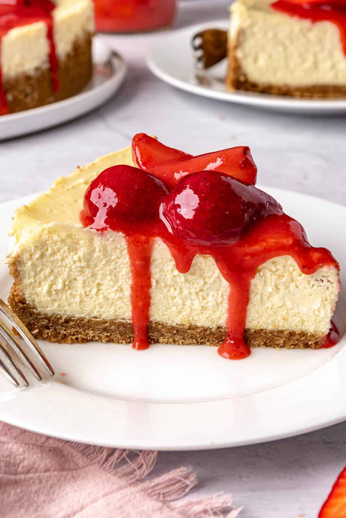 Cheesecake with 2 slices removed to small plates nearby.