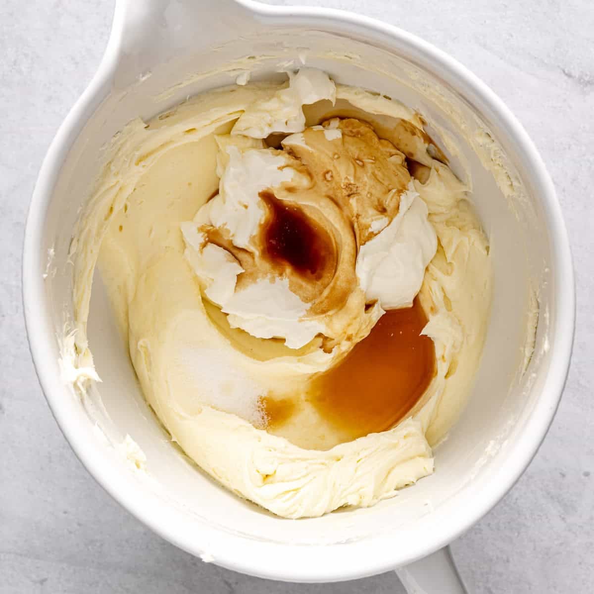 Cream cheese and sugar after fully combining with sour cream, vanilla, lemon juice, and salt added.