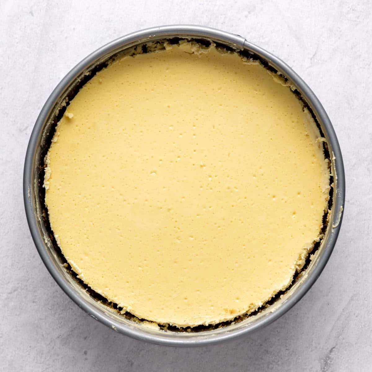 Cheesecake after baking and chilled with springform pan propped open.