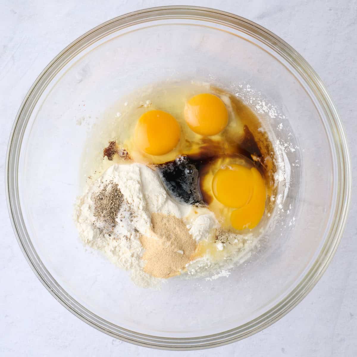 Eggs, flour, soy sauce, sesame oil, garlic, salt and pepper in a large bowl.