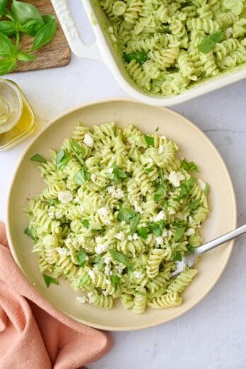 Pasta with green sauce made with feta served in a bowl.