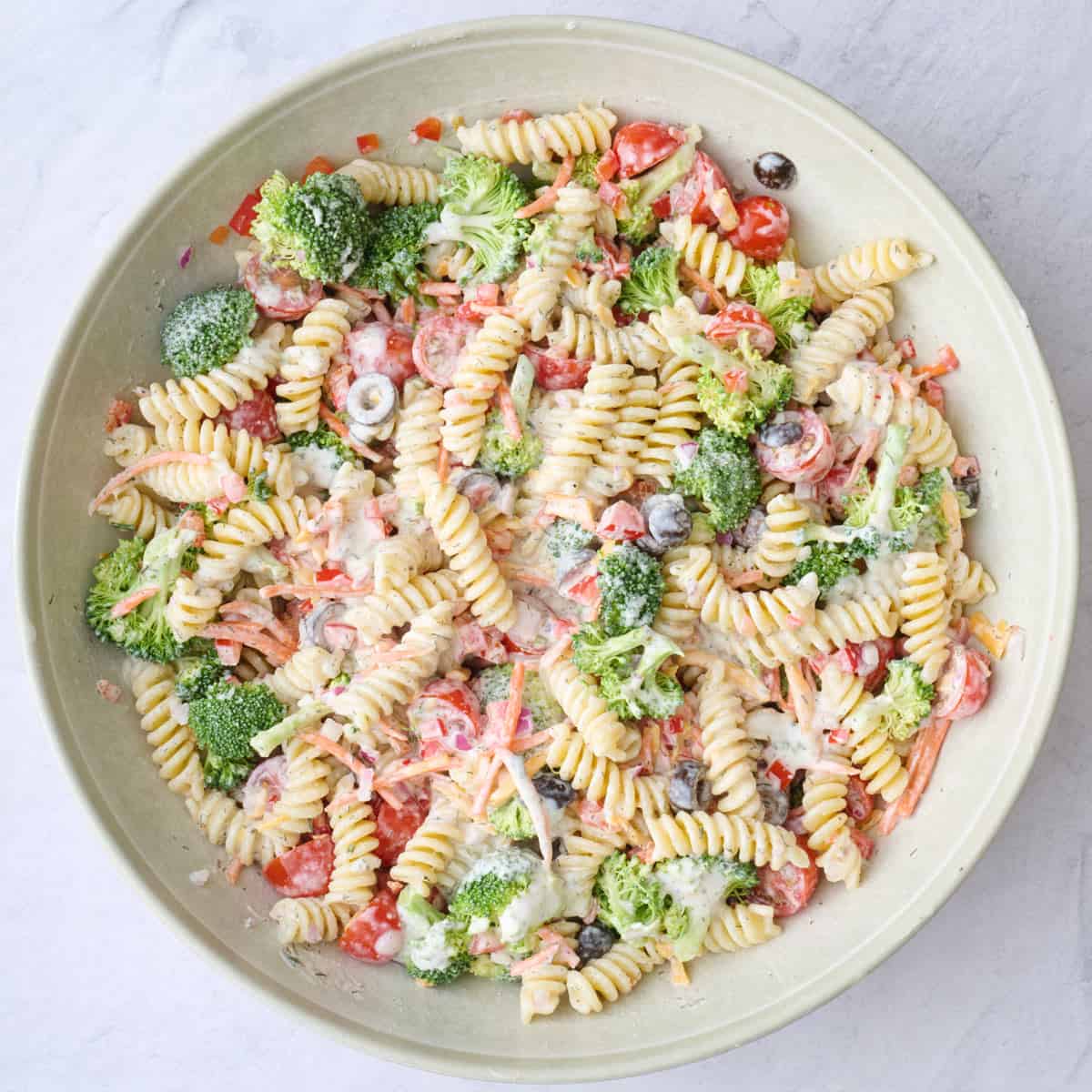 Ranch pasta salad in a serving bowl after mixing all of the ingredients together.
