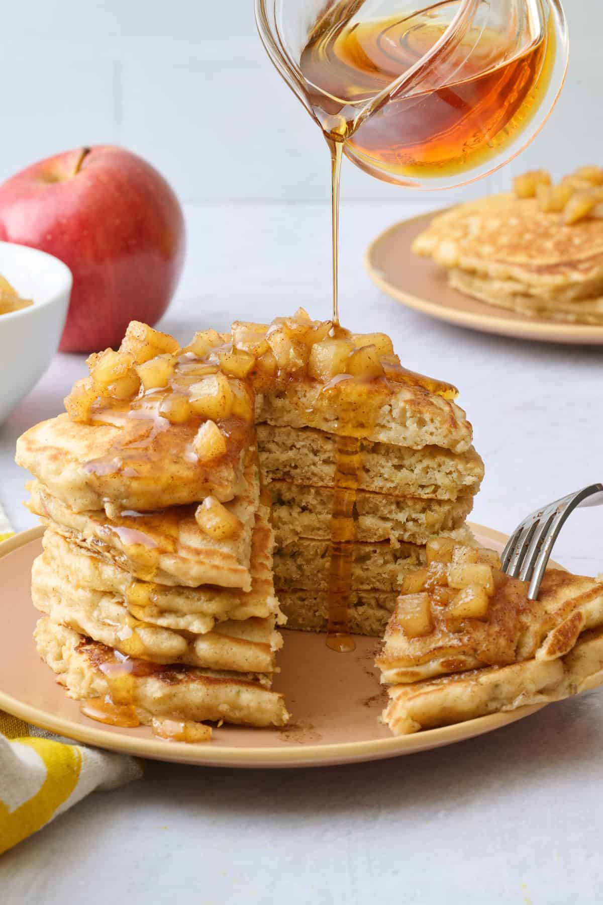 One plate with some maple syrup poured over and a bite taken out with fork resting on plate.