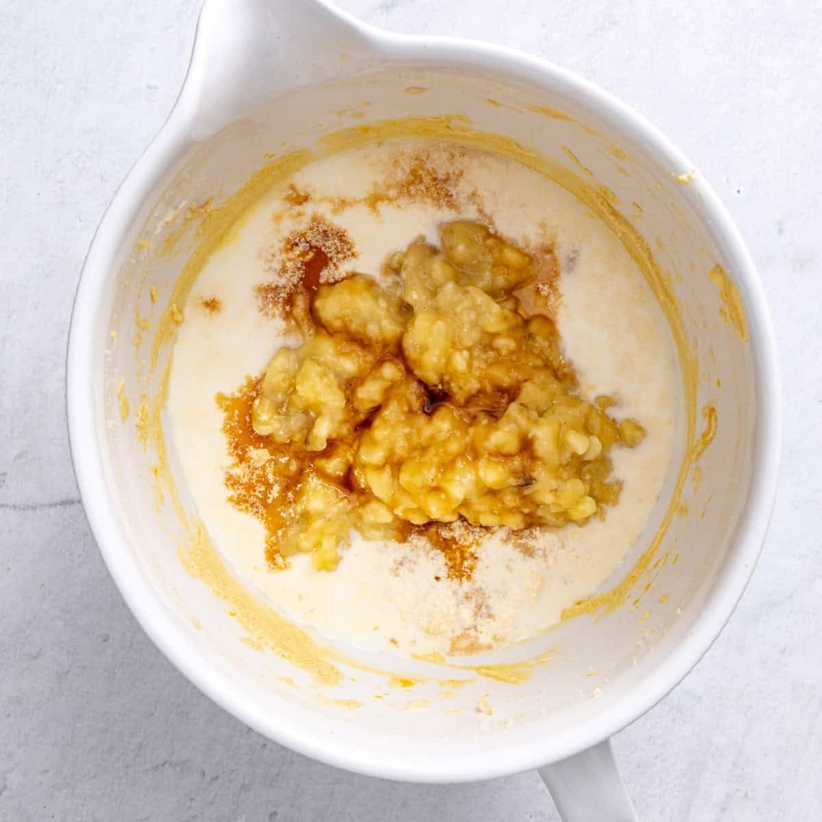 The bowl after all eggs are mixed in with milk, bananas and vanilla added before combining.