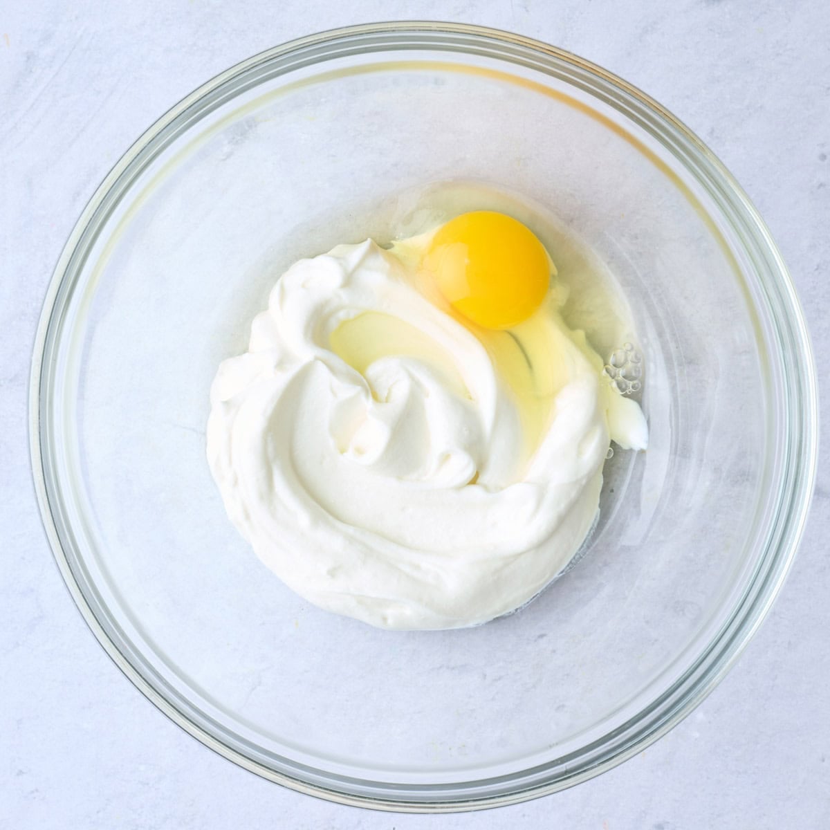 Yogurt and egg in a bowl before whisking.