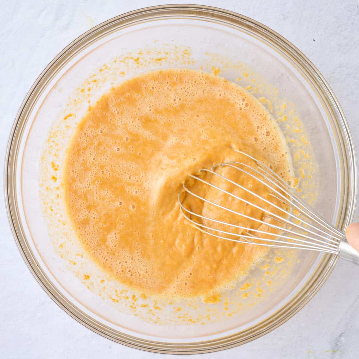 Whisking together wet ingredients with mashed sweet potatoes.