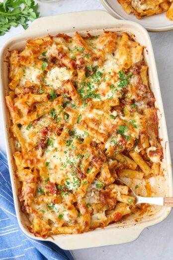 Baked ziti in the baking dish garnished with chopped parsley.