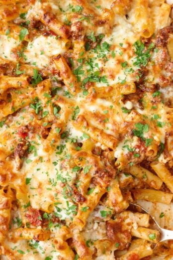 Baked ziti in the baking dish garnished with chopped parsley.