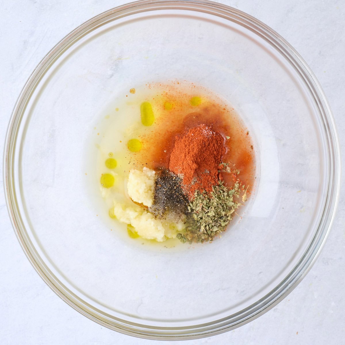 Oil, lemon juice, garlic and seasonings in a bowl before combining.