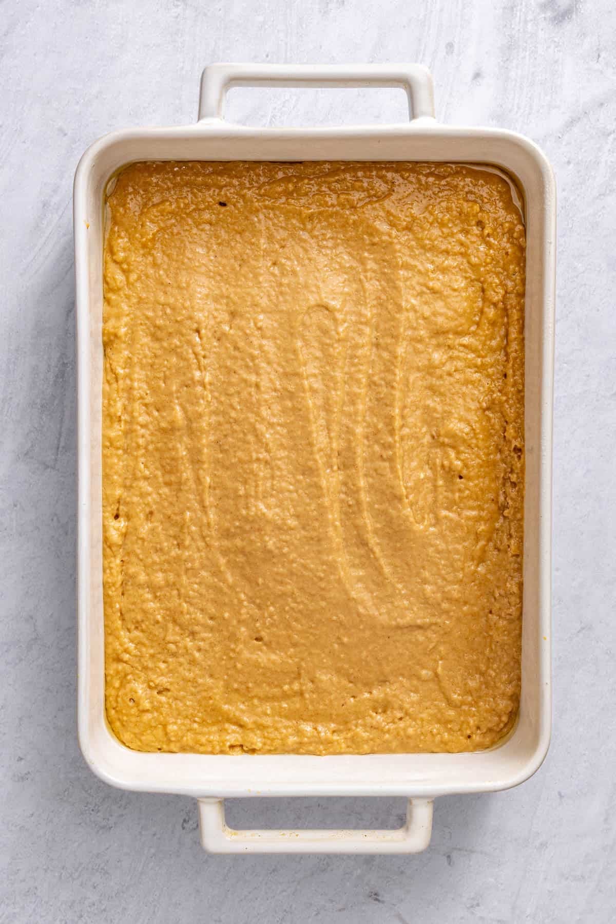 Batter poured into prepared ceramic baking dish before baking.