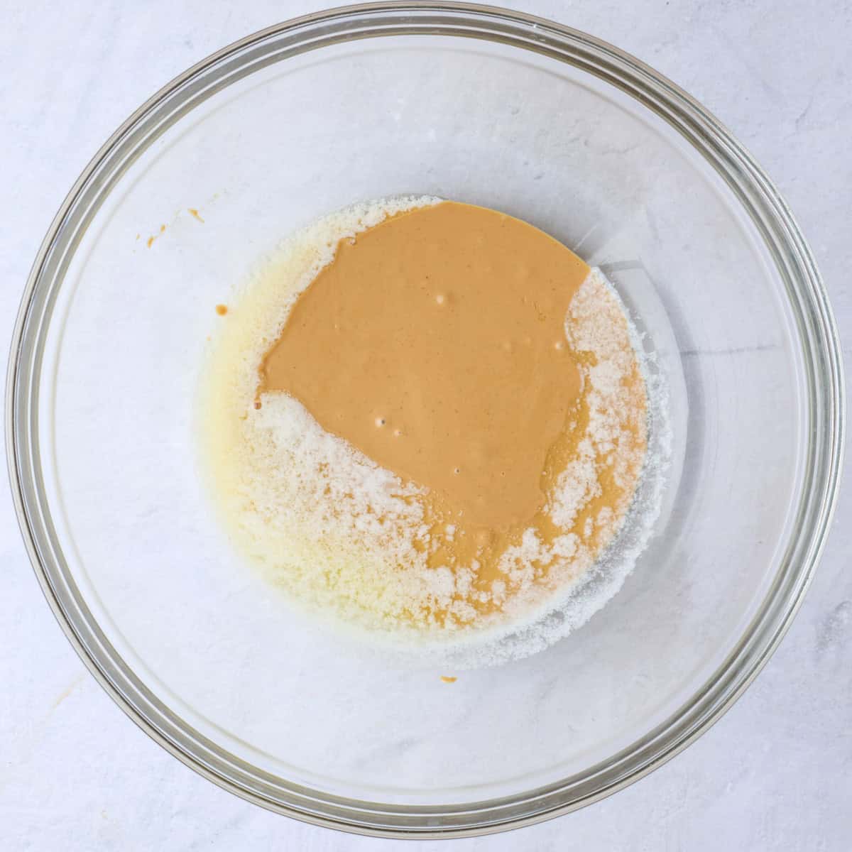 Peanut butter and butter in a small bowl after melted, but separated.